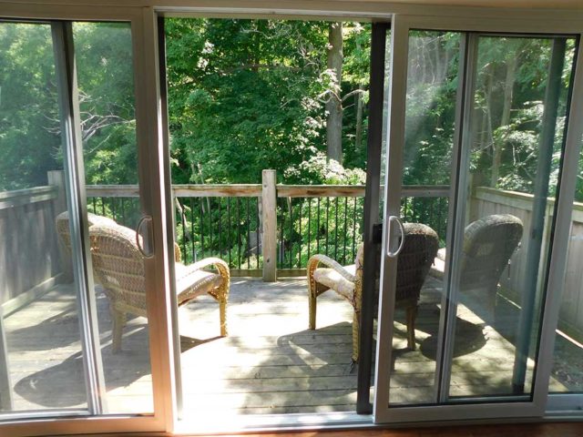 Balcony with two chairs and view of trees